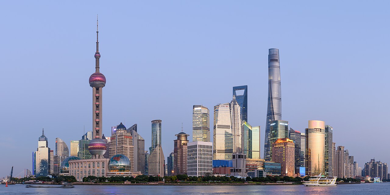 Shanghai’s illuminated Lujiazui skyline across the Huangpu River, including the Oriental Pearl Tower and Shanghai Tower.